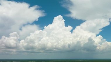 Beyaz kabarık kümülüs bulutlarının zamanı yaz mavi gökyüzünde şekilleniyor. Hareket eden ve değişen bulutlu hava durumu.