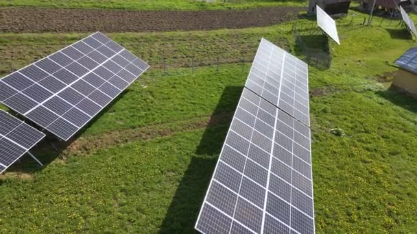 クリーンな生態系電気エネルギーを発生させるために裏庭の地面に独立したフレームに取り付けられた太陽光発電パネル 自律住宅の概念 — ストック動画