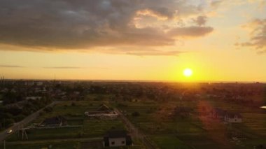 Köy evlerinin ve uzak yeşil tarlaların hava manzarası. Parlak yaz akşamlarında ekinlerin büyüdüğü tarlalar..