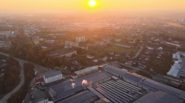 Sanayi binasının çatısına yeşil ekolojik elektrik üretmek için monte edilen mavi fotovoltaik güneş panellerinin hava görüntüsü. Sürdürülebilir enerji konsepti üretimi.