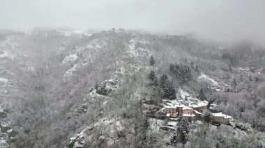 Aerial winter landscape of dense historic center of Thiers town in Puy-de-Dome department, Auvergne-Rhone-Alpes region in France. Rooftops of old buildings and narrow streets at snowfall.