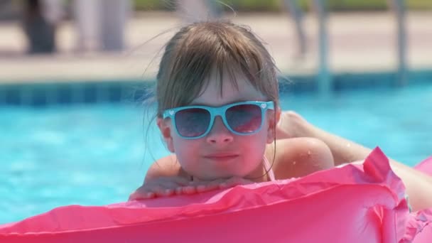 夏の太陽の下でリラックスした若い女の子は 熱帯の休暇中にプールで膨脹可能な空気マットレスで泳ぐ 夏のアクティビティコンセプト — ストック動画