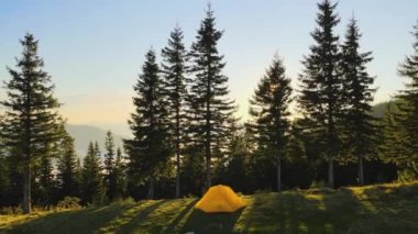 Parlak güneşli bir akşamda dağ kamp alanındaki turist kamp çadırının hava manzarası. Aktif turizm ve yürüyüş konsepti.