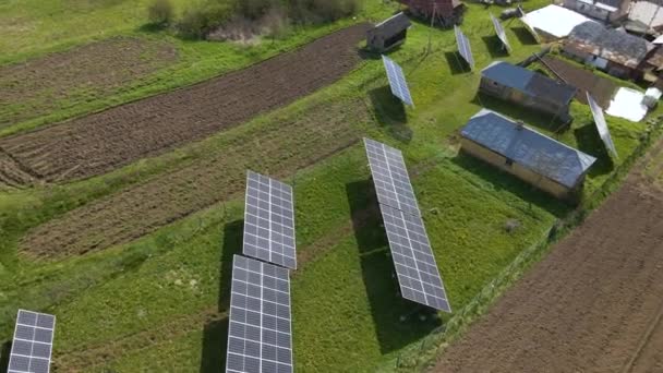 クリーンな生態系電気を生成するための裏庭の地面に取り付けられた青い太陽光発電パネルの空中ビュー 再生可能エネルギーの概念の生産 — ストック動画