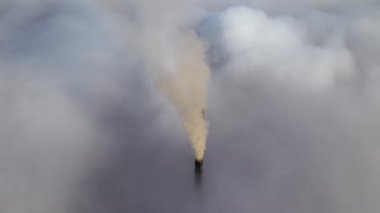 Kömür santrali yüksek borular siyah zehirli duman yayıyor. Beyaz sisli havada yukarı doğru hareket ediyorlar. Fosil yakıt kavramına sahip elektrik enerjisi üretimi.