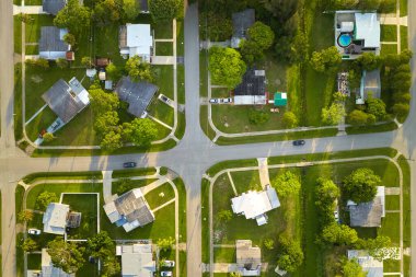 Aerial landscape view of suburban private houses between green palm trees in Florida quiet rural area at sunset.
