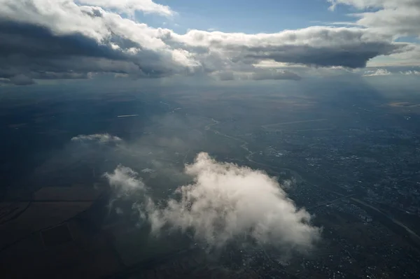 Aerial view at high altitude of earth covered with puffy cumulus clouds forming before rainstorm.