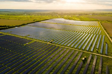 Temiz ekolojik elektrik enerjisi üretmek için birçok sıra güneş fotovoltaik paneli bulunan sürdürülebilir büyük elektrik santralinin havadan görünüşü. Sıfır emisyon kavramı ile yenilenebilir elektrik.
