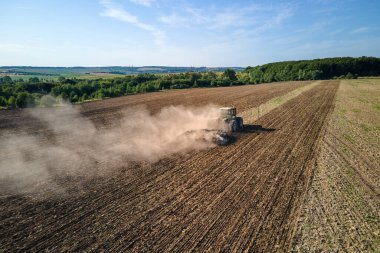 Tarım tarlasını süren traktörün havadan görünüşü yaz mevsiminde tohum ekmek için toprağı hazırlıyor..