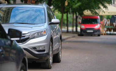 Sokak kenarında park halindeki arabalarla şehir trafiği.