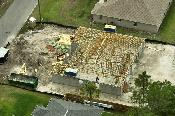 Aerial view of suburban private house wit wooden roof frame under construction in Florida quiet rural area.