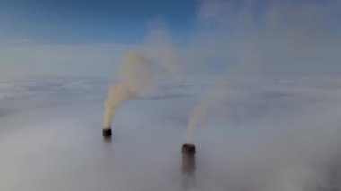 Kömür santrali yüksek borular siyah zehirli duman yayıyor. Beyaz sisli havada yukarı doğru hareket ediyorlar. Fosil yakıt kavramına sahip elektrik enerjisi üretimi.