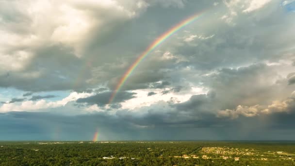 暗い空に形成された暗い嵐の雲に対するカラフルな虹郊外の町エリアに大雨の前に — ストック動画