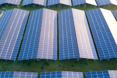 Temiz ekolojik elektrik enerjisi üretmek için sıra sıra güneş fotovoltaik panelleri olan sürdürülebilir büyük elektrik santralinin havadan görünüşü. Sıfır emisyon kavramı ile yenilenebilir elektrik