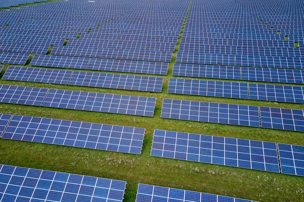クリーンな電気エネルギーを生成するための太陽光発電パネルの行を持つ大規模な持続可能な電気発電所の空中ビュー 排出ゼロの再生可能エネルギーの概念 — ストック写真