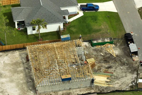 Aerial view of suburban private house wit wooden roof frame under construction in Florida quiet rural area.