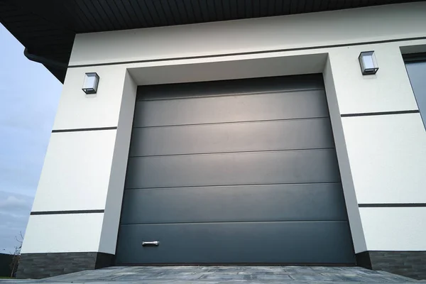 Automatic electric roll-up commercial garage gate or push-up door in modern private building ground floor.