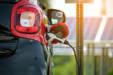 Şehrin caddesinde park halindeki güneş enerjisi yenilenebilir enerji kaynağından elektrik yüklü bir elektrik prizi..