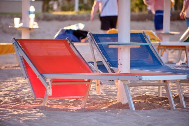 Yaz tatilinde kumlu sahil tarafında boş iskemleler. Tatiller ve kaçış konsepti.