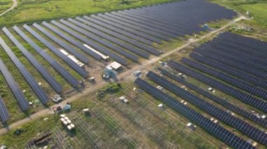 Metal çerçevede temiz elektrik enerjisi üreten birçok sıra güneş paneli bulunan büyük elektrik santralinin havadan görüntüsü. Yenilenebilir elektrik kaynaklarının geliştirilmesi.