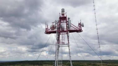 Ağ sinyali iletimi için kablosuz iletişim antenleri bulunan telekomünikasyon baz istasyonunun hava görüntüsü.