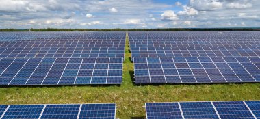 Temiz elektrik enerjisi üretmek için birçok sıra güneş fotovoltaik paneli bulunan sürdürülebilir büyük elektrik santralinin havadan görünüşü. Sıfır emisyon kavramı ile yenilenebilir elektrik.