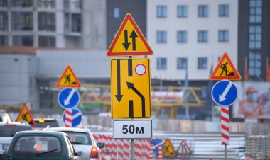 Yol çalışmaları trafik işaretlerini uyardı. Şehir caddesinde inşaat çalışması ve yavaş hareket eden arabalar..