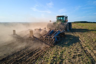 Tarım tarlasını süren traktörün havadan görünüşü yaz mevsiminde tohum ekmek için toprağı hazırlıyor..