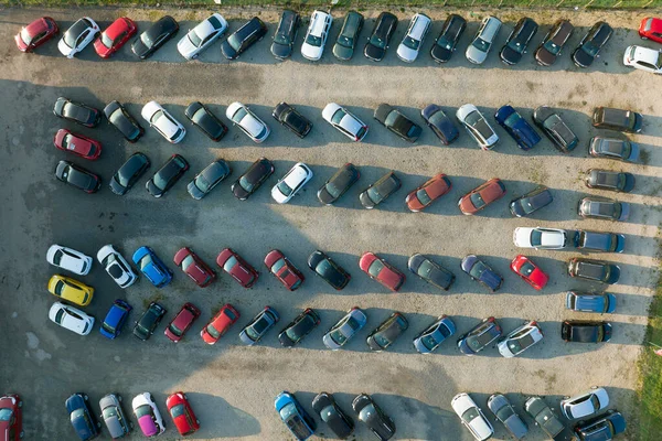 Aerial view of many colorful cars parked on dealer parking lot for sale.