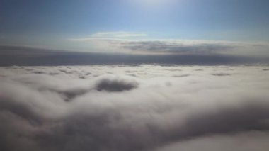 Dünya 'nın yüksek irtifasında, yağmur fırtınasından önce oluşan kabarık kümülüs bulutlarıyla kaplı uçak penceresinden hava görüntüsü.