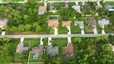 Florida 'nın sakin yerleşim bölgesinde yeşil palmiye ağaçları arasında özel evleri olan küçük bir Amerikan banliyö manzarası..