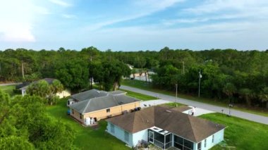 Florida 'nın sakin yerleşim bölgesinde yeşil palmiye ağaçları arasında özel evleri olan küçük bir Amerikan banliyö manzarası..