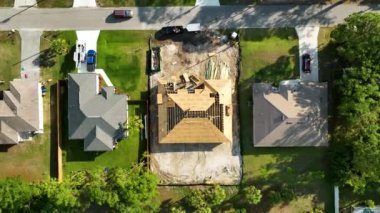 Florida 'nın sakin kırsal kesiminde yapım aşamasında olan banliyö özel evi manzaralı ahşap çatı iskeleti..