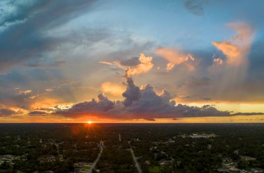 Florida 'daki yeşil palmiye ağaçları arasındaki banliyö özel evlerinin hava manzarası günbatımında sakin kırsal bölge.
