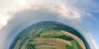 Dünya gezegeninin yüksek irtifasından yeşil ve sarı ekili tarım tarlaları ile aydınlık yaz gününde ekinlerin büyümesi..