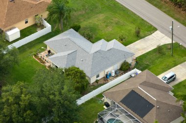 Florida 'nın sakin yerleşim bölgesinde yeşil palmiye ağaçları arasında özel evleri olan küçük bir Amerikan banliyö manzarası..