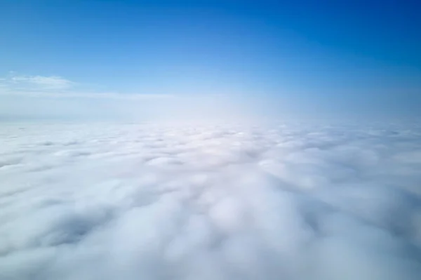 Aerial view from high altitude of earth covered with puffy rainy clouds forming before rainstorm.