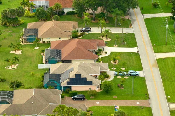 Aerial view of small town America suburban landscape with private homes between green palm trees in Florida quiet residential area.