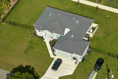 Tipik modern Amerikan özel evinin çatısı asfalt kiremitlerle ve bahçedeki yeşil çimlerle kaplı..