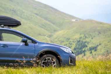 Blue off road car on mountain trail. Traveling by auto, adventure in wildlife, expedition or extreme travel on SUV automobile.