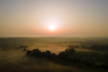 Parlak renkli günbatımı gökyüzü, batan güneş ve canlı bulutlar, karanlık manzaranın üzerinde..