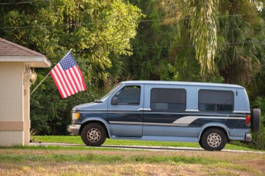 Klasik Amerikan minibüsü bir evin önüne park edilmiş. ABD seyahat kavramı.
