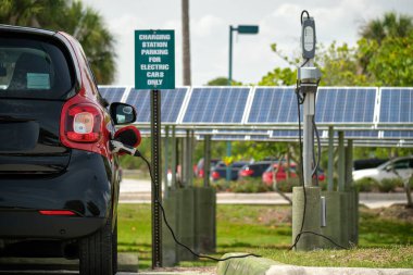 Şehrin caddesinde park halindeki güneş enerjisi yenilenebilir enerji kaynağından elektrik yüklü bir elektrik prizi..