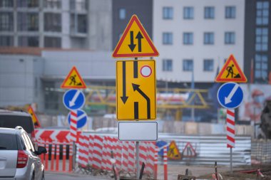 Yol çalışmaları trafik işaretlerini uyardı. Şehir caddesinde inşaat çalışması ve yavaş hareket eden arabalar..