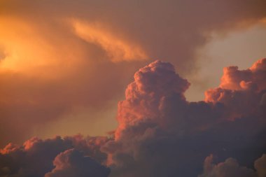 White fluffy cumulonimbus clouds forming before thunderstorm on evening sky. Changing stormy cloudscape weather at sunset.