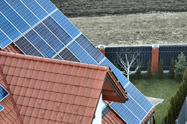 Residential house with rooftop covered with solar photovoltaic panels for producing of clean ecological electrical energy in suburban rural area. Concept of autonomous home.