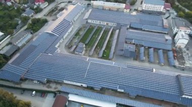 Sanayi binasının çatısına yeşil ekolojik elektrik üretmek için monte edilen mavi fotovoltaik güneş panellerinin hava görüntüsü. Sürdürülebilir enerji konsepti üretimi.