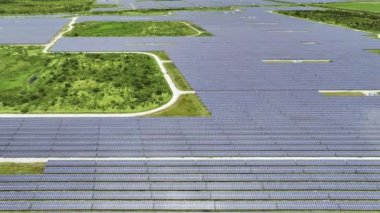 Temiz elektrik enerjisi üretmek için sıra sıra güneş fotovoltaik panelleri olan sürdürülebilir büyük elektrik santralinin havadan görünüşü. Sıfır emisyonlu yenilenebilir elektrik kavramı.