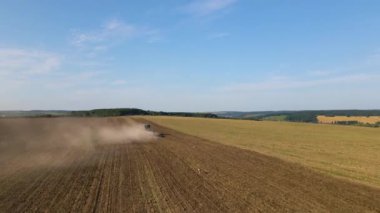 Tarım tarlasını süren traktörün havadan görünüşü yaz mevsiminde tohum ekmek için toprağı hazırlıyor..