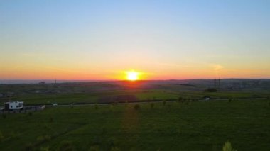 Yeşil ekili tarlaların, büyüyen ekinlerin ve parlak yaz akşamlarında uzak köy evlerinin hava manzarası..